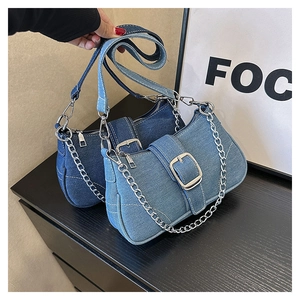 Detail of denim crossbody bags with silver chains in dark and light blue options