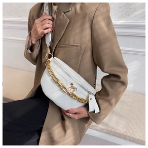Macro detail of white crocodile embossed leather bag with gold chain and horse logo