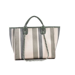 Striped canvas tote bag with faux leather handles and chain strap on white background