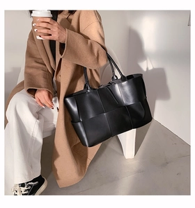 Détail du sac cabas noir tressé avec motif en damier large et anses fines élégantes