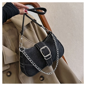 Detail of black denim bag featuring white contrast stitching and silver square buckle