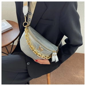 Detail of silver crocodile-embossed half-moon bag with gold horse logo and thick chain
