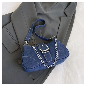 Detail of denim shoulder bag with silver chain and adjustable strap in retro style