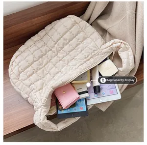 Large beige quilted down tote bag showing interior storage capacity for tablet and wallet