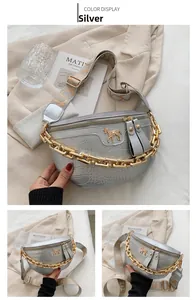 Detail of silver crocodile-embossed belt bag with gold chain and woven strap