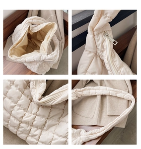 Detail view of cream quilted puffer bag showing zipper, interior space, and soft texture