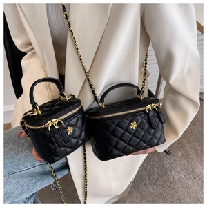 Details von zwei schwarzen gesteppten Beuteltaschen mit Goldblume und Kettenriemen