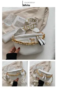 Detail of white crocodile pattern fanny pack with gold chain and abstract strap
