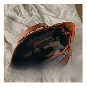 Interior view of large navy canvas tote bag showing storage for tablet and cosmetics