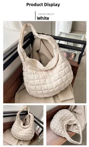 Close-up of white quilted puffer tote bag featuring soft square stitching and padded strap