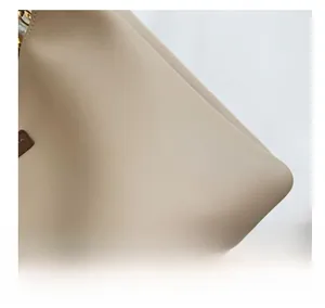 Detailed close-up showing the soft textured leather material of the beige tote bag