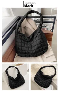 Detail of black quilted puffer tote bag with soft padded texture and wide shoulder strap