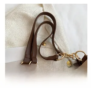 Detail of comfortable brown leather strap and gold metal buckle on tote shoulder bag