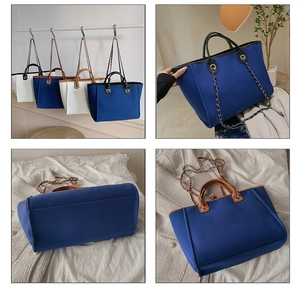 Detail view of canvas tote bags in blue and white with metal chain straps and leather handles
