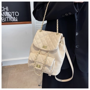 Detail of beige quilted mini backpack with gold chain straps and twist-lock closure