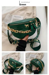 Detail view of dark green croc-effect crescent bag with gold horse ornament and chain