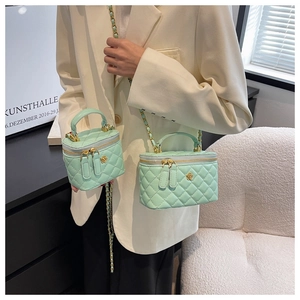 Detailansicht der minzgrünen Stepptaschen mit Kette, präsentiert von einem Model im Dekor