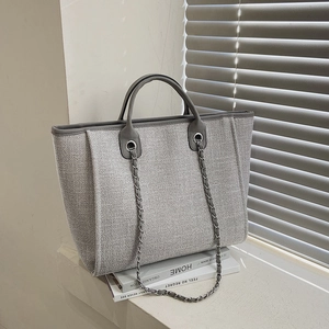Large gray woven canvas tote bag with chain shoulder strap and leather handles