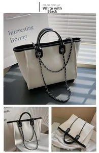 Detail of canvas tote bag showing black leather trim and woven chain strap details