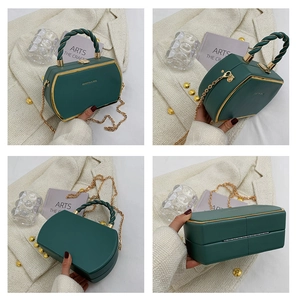 Detail view of dark green polygonal handbag with gold metal edges and chain strap