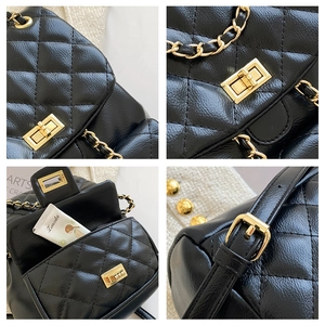 Detail view of black quilted leather backpack with gold clasp and chain strap