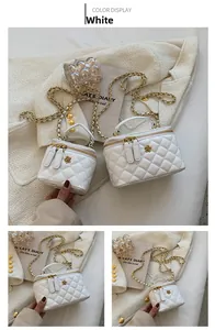 Detail view of white quilted crossbody bag set with elegant gold chain and flower zipper
