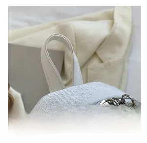 Dettaglio del tessuto jacquard bianco e della zip in metallo argento a forma di nuvola