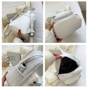 Dettaglio interno di un mini zaino bianco in jacquard floreale con varie tasche