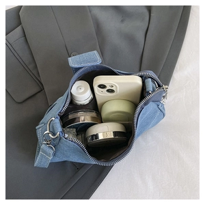 Top view of denim shoulder bag interior showing main pocket and zipper compartment