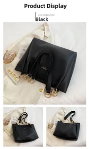 Detail view of black leather tote bag featuring gold ring handles and logo patch