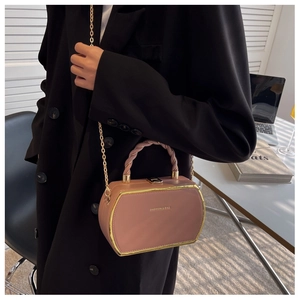 Detail of pink hexagonal crossbody bag with golden frame and woven handle