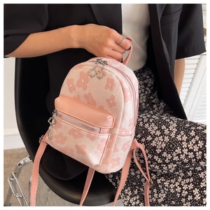Dettaglio di un mini zaino floreale con cerniera a fiore argento e spalline rosa