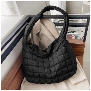 Detail of the black quilted cloud tote bag's puffy texture and block stitching finish