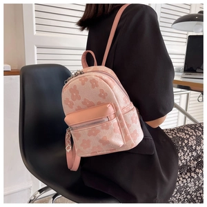 Dettaglio di un mini zaino rosa con motivo floreale indossato per un look casual quotidiano