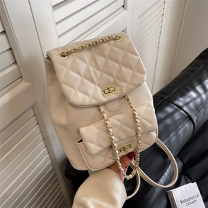 Chic beige quilted backpack with gold chain straps and turn-lock closure in lifestyle setting