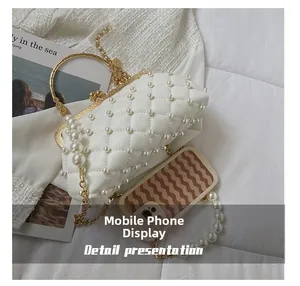 Vue détaillée du sac de soirée blanc matelassé avec perles et téléphone pour la taille