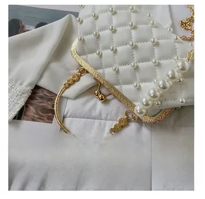 Détail d'un sac de soirée matelassé blanc avec perles et fermoir vintage doré