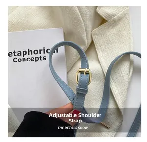 Close-up of adjustable light blue PU leather shoulder strap with pale gold metal buckle