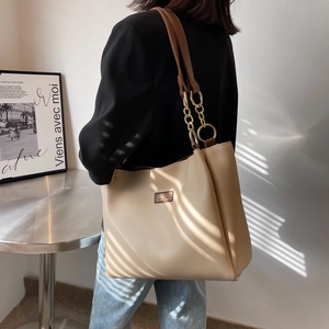 Women's cream tote bag with brown leather straps and gold chain detail on shoulder