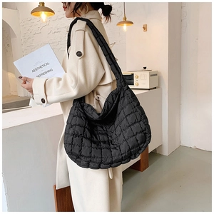 Close-up of black quilted nylon tote bag with classic diamond stitch and wide shoulder strap