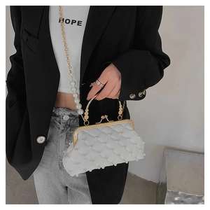 Détail d'un sac à main matelassé blanc orné de perles avec fermoir vintage doré