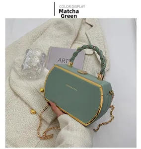 Close-up of matcha green structured handbag with gold frame and woven top handle