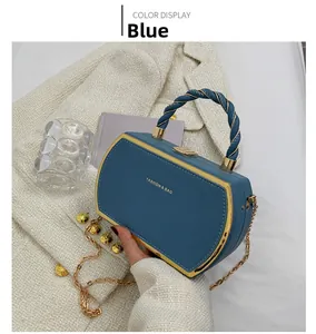 Detail of navy blue leather handbag with golden metal frame and twisted rope handle