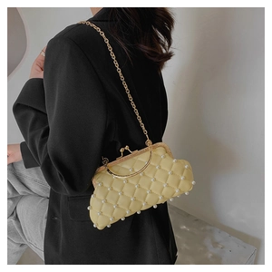 Détail du sac matelassé jaune clair à perles porté par un mannequin en tailleur