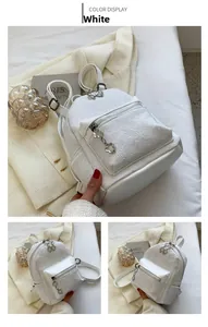 Dettaglio di zaino in pizzo bianco con trama floreale e tirante in metallo a fiore