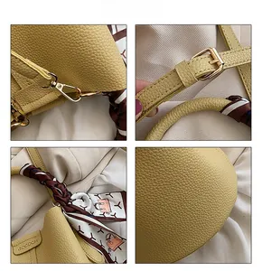 Detailed view of yellow lychee leather bag with gold hardware and silk scarf handle