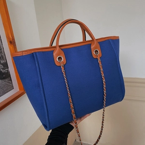 Large capacity blue canvas tote bag with brown leather trim and metal chain strap