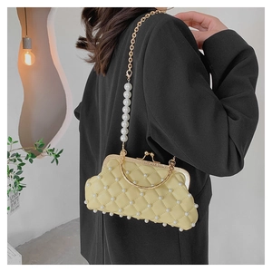 Détail du sac matelassé crème avec ornements en perles et fermoir en métal doré