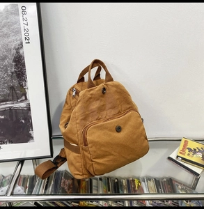 Detail view of washed canvas backpack with metal magnetic buckle and reinforced handles