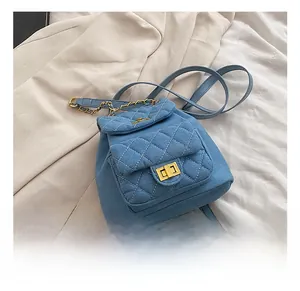 Close-up of blue denim quilted mini backpack with golden twist lock and chain strap detail